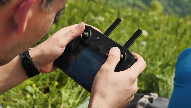 Close-up of the drone operator's fingers. Joystick control of professional controller quadrocopter in nature. Concept of modern technologies of intelligent digital wireless device