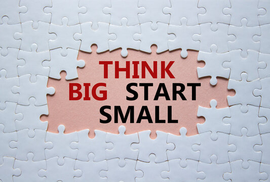 Think big start small symbol. Concept words Think big start small on white puzzle. Beautiful pink background. Business and Think big start small concept. Copy space