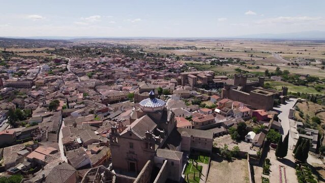 Aerial view orbiting Oropesa Iglesia del Colegio de Jesuitas town neighbourhood in the Spanish countryside