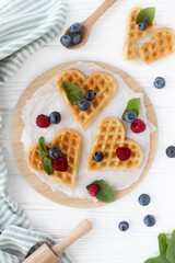 Dessert Belgian waffles in the shape of hearts with berries