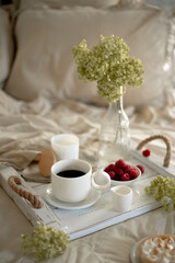 Still life with a cup of coffee with milk, flowers and cakes
