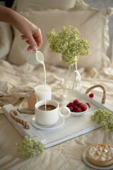 Still life with coffee, into which milk is poured. Female hand