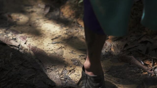 Close up dolly, footsteps walking in the jungle with shadow casted, Adidas kampung
