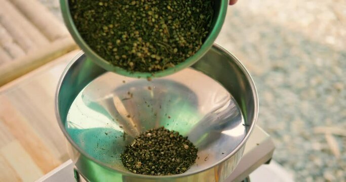 Seeds being poured into Oil Press Machine.  4k, slomo