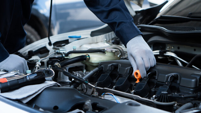 Auto machanic checking oil in car engine and car maintenance in garage. Repair service.Car Machanic.Car repair and maintenanc concept.