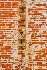 Vertical wall of busted red bricks jutting out with white paint splatter background asset