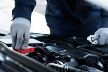 Auto machanic Checking and change the battery in garage. Repair service.Car Machanic.Car repair and maintenanc concept.