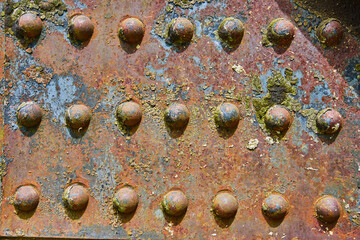Colorful background asset rusting metal rivets with flaking yellow bits and blue iron patches