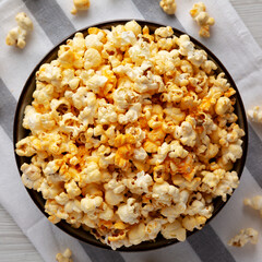 Homemade Pop Corn with Cheese in a Bowl on a white wooden background, top view. Flat lay, overhead, from above.
