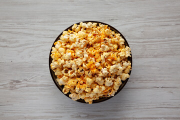 Homemade Pop Corn with Cheese in a Bowl on a white wooden background, top view. Flat lay, overhead, from above.