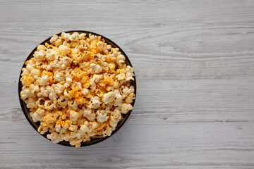 Homemade Pop Corn with Cheese in a Bowl on a white wooden background, top view. Flat lay, overhead,...
