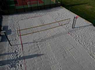 white sand beach volleyball court. white soft dunes fenced with nets. The lines of the playing...