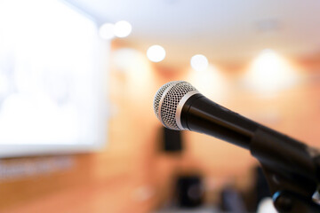 Wired microphone set up on the front of conference room close up with blurred background.