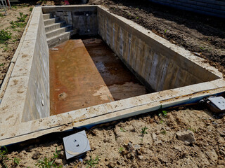 construction of a new swimming pool in the garden. mud brickwork and stairs in the corner. concrete...