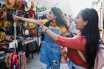 two young latin women travellers in tourist market in Mexico Latin America, hispanic backpacker...