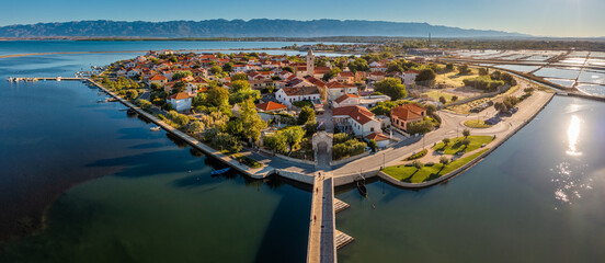 Nin, Croatia - Aerial panoramic view of the historic town and small island of Nin with traditional salt still fields and blue Adriatic sea on a sunny summer morning in Dalmatia region of Croatia