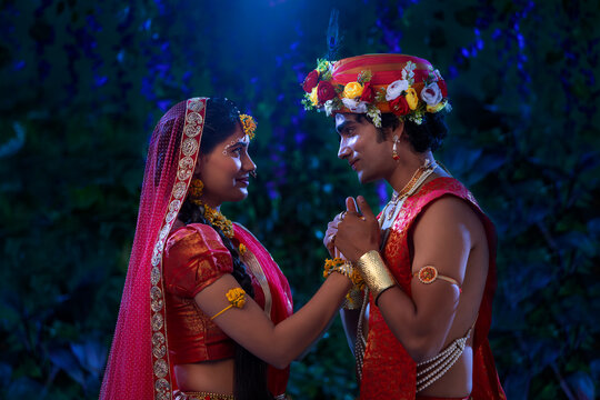Young man and woman dressed up as Radha and Krishna and romancing on the occasion of Janmashtami