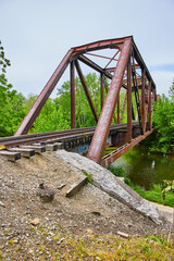 Fototapeta na wymiar Rusty iron train track bridge at Heart of Ohio Trail with Kokosing River flowing underneath