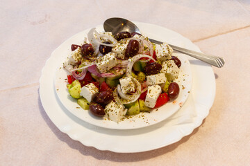 Greek salad with fresh vegetables, feta cheese and olives on a table