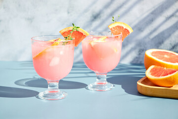 Summer chilled cocktails with citrus fruits. Drink with grapefruit or red orange and a sprig of thyme.