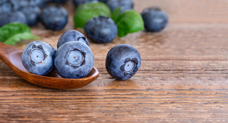 Close up wooden spoon with blueberries on wooden rustic background