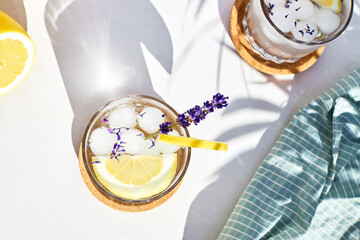 Top view of a glass of refreshing cocktail with lemon slices and fresh lavender flowers. Summer...