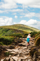Fototapeta premium A girl climbs a mountain