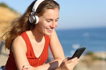 Fototapeta na wymiar Happy teenage girl listening music on the beach