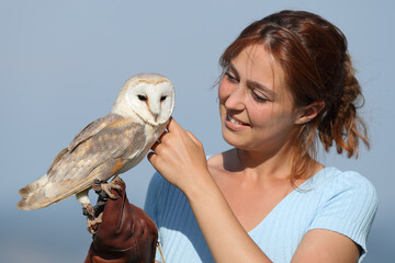 Woman caressing owl outdoors