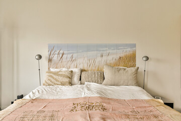 a bed in a room with a painting on the wall behind it and an untiful headboard above