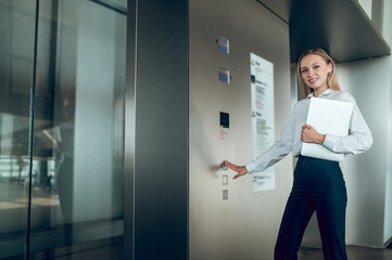 Blond young woman near the elevator in the business center