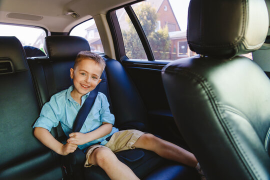 Smiling boy wearing seat belt in car