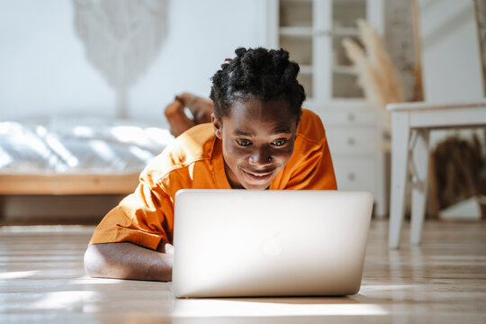 Freelancer working with laptop lying on floor at home