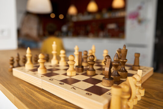Wooden chess board with pieces on window sill