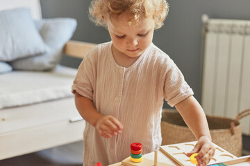 Cognitive development puzzles. Montessori learning approach. Wooden construction set. little blonde...