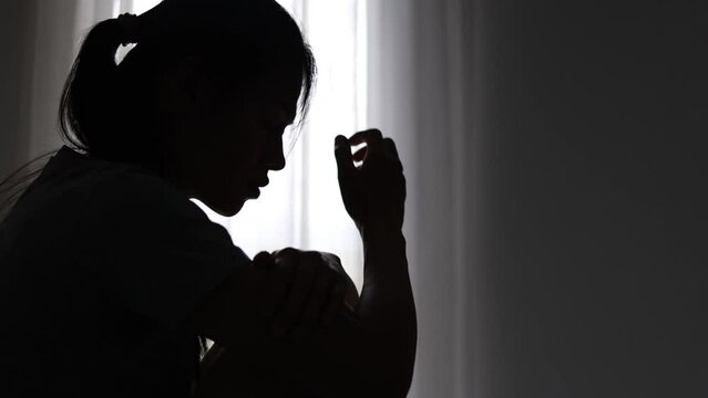 silhouette of a sad woman in the dark domestic violence Family problems. Stress. Violence. Depression and suicide concept.