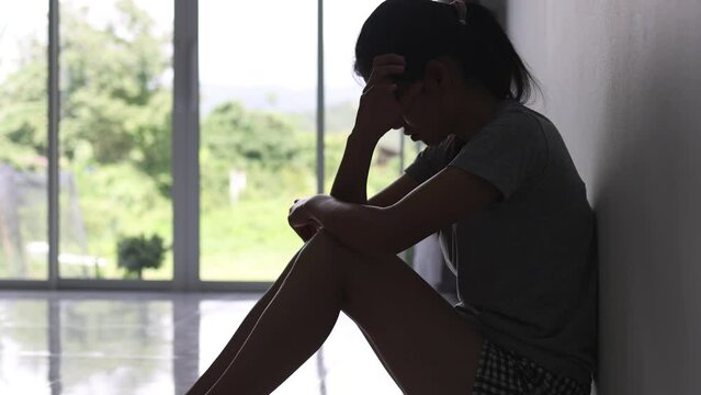silhouette of a sad woman in the dark domestic violence Family problems. Stress. Violence. Depression and suicide concept.