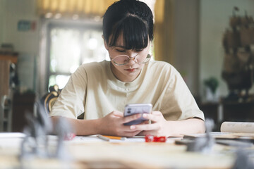 Young adult asian woman using smartphone for role playing tabletop and board game