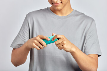 Happy smiling guy opening facial wash bottle, preparing to apply the beauty product on his face. Young man uses hydrating skin cleanser in his skincare routine. Men's self-care. Cropped portrait.