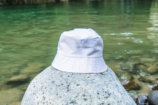 Nature's enchanting embrace sets the stage for a captivating mockup image featuring a white blank bucket hat perfectly positioned in the landscape