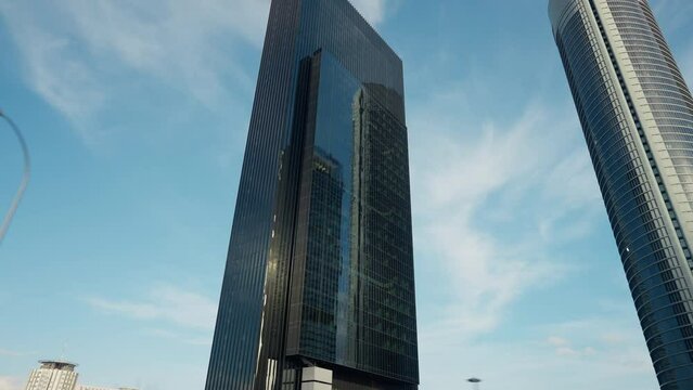 Live camera riding passing skyscrapers in urban city on sunny street in the morning. Glass office buildings in sunshine outdoors