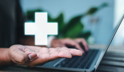 insurance, supporting, health, financial, life, life insurance, investment, technology, assurance, retirement. typing with one hand, holding red cross icon symbolizing insurance and healthcare.