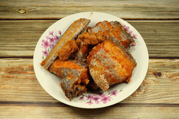 Pile of deep fried Cutlass fish (Largehead Hairtail) serving on the plate. Famous crispy and crunchy seafood menu in Asia restaurant.