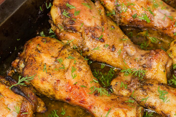 Baked chicken legs on tray, close-up in selective focus