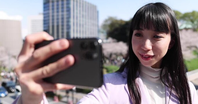 A portrait of selfie by Japanese woman behind cherry blossom closeup