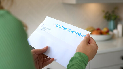 Close Up Of Woman Opening Letter About Increase Repayment On Mortgage During Cost Of Living Crisis
