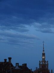 Recinto modernista Sant Pau en Barcelona, edificio antiguo de principios de siglo 19, torre de iglesia con reloj y cruz, al atardecer con cielo gris