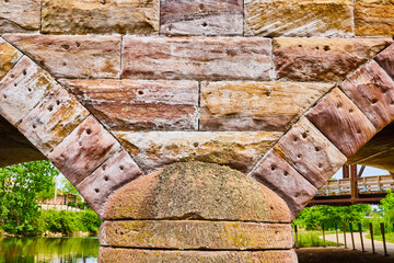Gorgeous stone brick bridge with partial geometric arches close up rustic white and gold colors