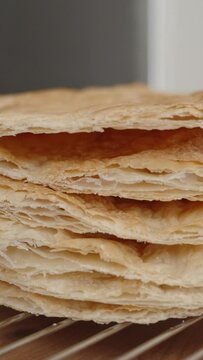 Vertical video. Baked layers of puff pastry, a preparation for Napoleon cake.