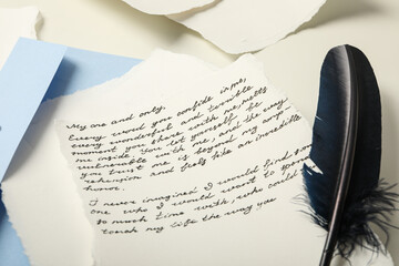 Paper, letter with text and bird feather on white background, close up